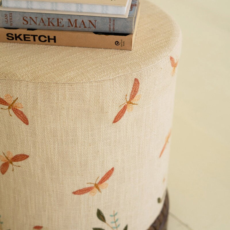 Cream Upholstered Ottoman with Embroidered Detail and Carved Wood Base